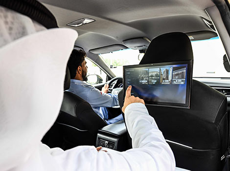 Image of a Dubai taxi rider using an interactive screen in a taxi